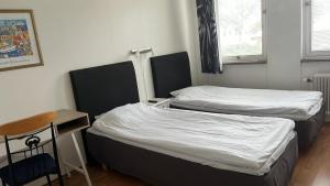 卡尔斯克鲁纳得罗宁家塔斯旅舍的小型客房配有两张床、一张桌子和一把椅子。