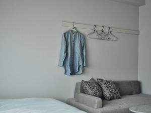 广岛FAV HOTEL HIROSHIMA STADIUM的一间配有沙发的房间和挂在墙上的外套