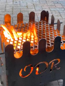 Clodockunique sheperds hut ensuite & kitchenette的火焰在金属烧烤炉中燃烧