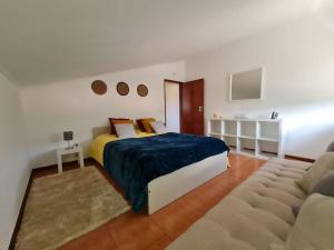 辛特拉Alojamento 3 vistas的一间卧室配有一张特大号床和一张沙发