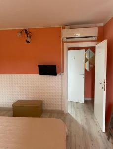 卡斯泰尔佩特罗索卡斯特尔佩特洛索住宿加食物旅馆的一间卧室拥有橙色的墙壁,设有一张床和一扇门