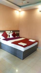 尼杜巴塞莱Alfa Inn的一间卧室配有一张带红色枕头的大床