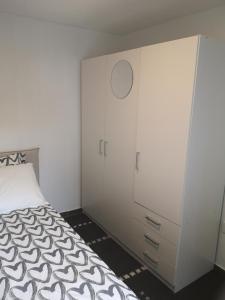 哥德堡Minilägenhet的卧室配有白色橱柜和1张床