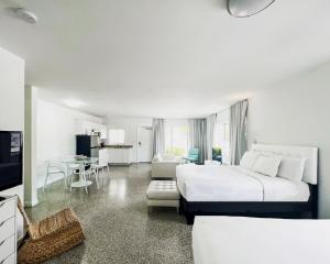 劳德代尔堡Tranquilo的一间白色的卧室,配有一张大床和一个客厅