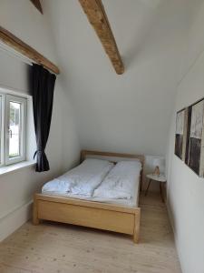 约灵Bjergby Guesthouse的一间带床的卧室,位于带窗户的房间内