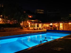 特罗吉尔Bella Vista apartments with hot pool and jacuzzi的夜间在游泳池里的人