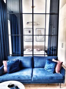 弗罗茨瓦夫IDYLLA Apartamenty w sercu Wrocławia na Ostrowie Tumskim的客厅配有带枕头的蓝色沙发
