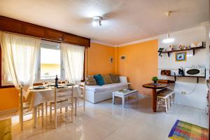 厄尔梅达诺Alquilaencanarias-Medano Tío Claudio beachfront的客厅配有沙发和桌子