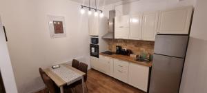 比斯特里察Apartament Calea Moldovei Residence - minibar si parcare GRATIS的厨房配有白色橱柜、桌子和冰箱。