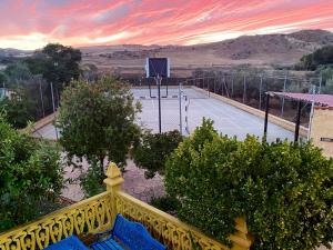 阿达莱斯Finca Villa Rey的一个带黄色围栏和蓝色长凳的网球场