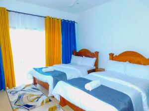 蒙巴萨SWEET BREEZE HOMES的一间卧室设有两张床和窗户。
