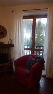 克拉维埃coeur de neige的一张红色沙发,坐在大窗户前