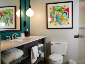 亚特兰大亚特兰大维宁斯爱达格酒店的浴室设有水槽,卫生间墙上挂有两张照片。