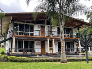 阿拉胡埃拉马蒂诺Spa及度假酒店的带阳台和棕榈树的房子