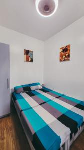 马尼拉Staycation in Alabang By Angela的蓝色白色客房的一张床位