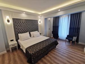 伊斯坦布尔Luxx Garden Hotel的一间卧室配有一张大床和大床头板