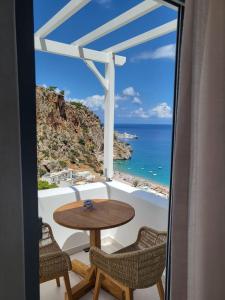 卡尔帕索斯Agnantema luxury suites的海景阳台上的桌椅