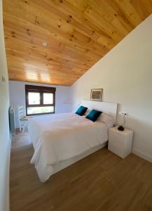 PenagosCasa Los Rinocerontes的卧室配有一张白色大床和木制天花板
