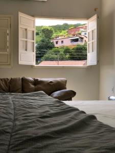 皮拉尼亚斯Casa Lampião的一间带沙发和大窗户的卧室