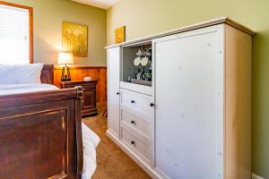 坎布里亚J Patrick Inn的卧室配有一张位于床边的白色大橱柜
