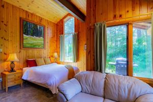 Camp ShermanLake Creek Lodge的一间卧室配有一张床、一张沙发和窗户。