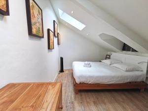 南特L'Ecrin des bords de l'Erdre - Les Maisons de Madeleine的卧室配有白色的床,铺有木地板