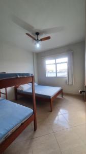 皮乌马Edifício Ferreira - Apartamentos temporadas的客房设有两张床和吊扇。