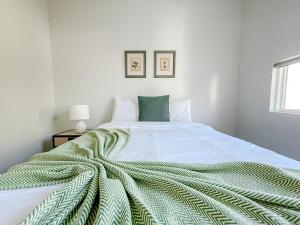 博林格林Sleepover 1BD 1BA Downtown Bowling Green Apartments的一间白色卧室,床上铺有绿毯