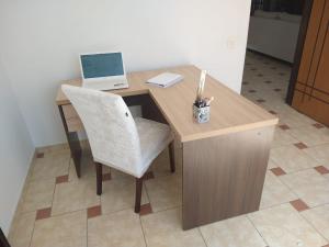 库里提巴Sobrado Lindóia的一张带笔记本电脑和椅子的木桌