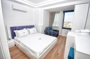 伊兹密尔Urla Marin otel的白色的客房配有一张床和椅子