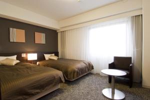 福冈多美迎博多祇园酒店的酒店客房带两张床、椅子和窗户