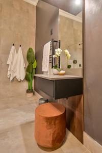 布隆方丹Summer PALACE Guesthouse的一间带水槽和木凳的浴室