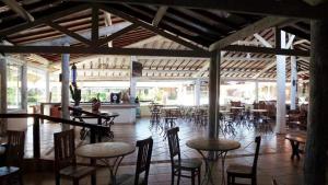 阿蒂巴亚Hotel Fazenda Hípica Atibaia的一间带桌椅的餐厅以及一间配有桌子的房间