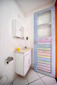 安格拉杜斯雷斯Pousada Água Marinha-Familias & Pets的一间带水槽和五颜六色门的浴室
