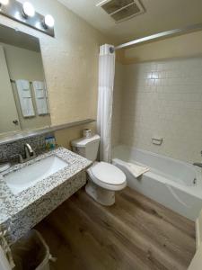 埃尔森特罗Travelodge by Wyndham Imperial - El Centro的浴室配有盥洗盆、卫生间和浴缸。