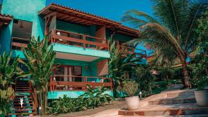 阿拉亚尔达茹达Cores do Arraial Residence Hotel的一座棕榈树的蓝色房子