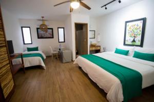 坎昆Hotel Tequila Cancun的酒店客房,配有两张带绿床单的床