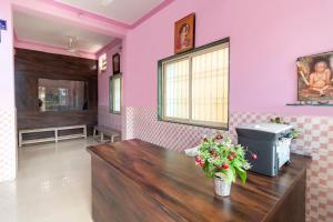奥兰加巴德SPOT ON Shree Gajanan的沙龙设有粉红色的墙壁和花木桌