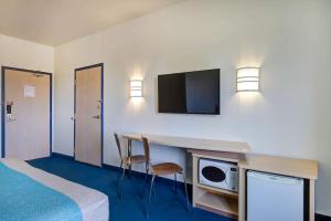 大草原城大草原6号汽车旅馆 的酒店客房配有一张床和一张带微波炉的书桌