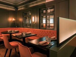 卢森堡索菲特的一间设有两张桌子和红色摊位的餐厅