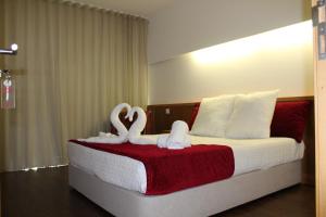 法蒂玛Casa Avé Maria的卧室配有2张天鹅装饰的床。