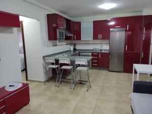 拉雷斯廷加VV LA ISLA的厨房配有红色橱柜和桌椅