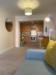伯恩茅斯1 bedroom apartment in the heart of Bournemouth的一间带蓝色沙发的客厅和一间厨房