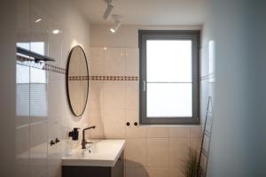 不来梅港Bheaven I Sea Pilot Premium Apartment的一间带水槽和镜子的浴室以及窗户。