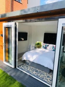 曼彻斯特MeeZee Pearl Double Bed Lodge With Free Parking的卧室设有玻璃门内的一张床