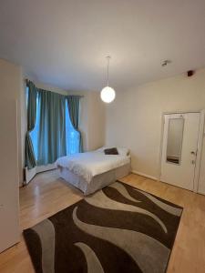 伦敦Bruce Rooms的卧室配有一张床,地板上铺有地毯