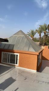 马拉喀什Riad Lyna的一座有棕榈树屋顶的建筑