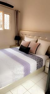 马拉喀什Riad Lyna的卧室配有带粉色和白色枕头的大床