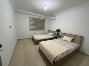 莫纳斯提尔Palm Lake Resort Folla Monastir/Sousse的一间卧室设有两张床和窗户。