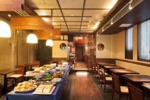 大阪MYSTAYS 堺筋本町酒店的用餐室配有长桌,摆放着食物